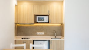 A compact kitchen with a microwave, sink, and a small refrigerator. - Apartment 'Apartamento Bon Aire N1' with Shared Pool, Wi-Fi and Air Conditioning (Cala Ferrera)