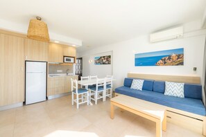 A compact living space with a kitchenette, dining area, and seating area.