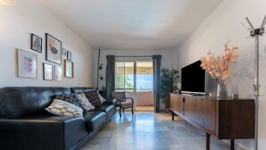 Een moderne woonkamer met een leren bank, een houten kast en een flatscreen televisie.