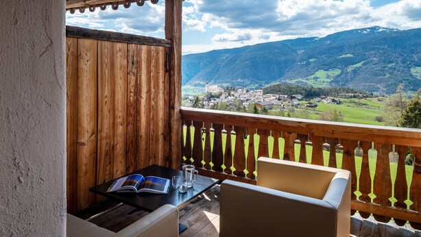 A wooden deck with a table and chairs, overlooking a mountainous landscape. - Apartment 'Biohof Maurer Apt Vogelstimmen' with Mountain View, Shared Garden and Wi-Fi (Laion)
