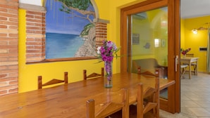 Comedor con una mesa de madera, sillas y un jarrón de flores.