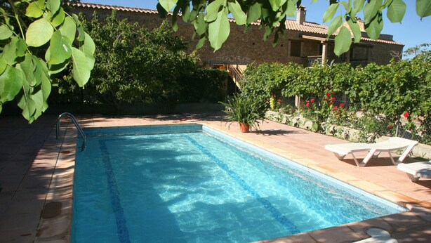 A rectangular swimming pool with a ladder on one side, surrounded by a patio area with lounge chairs and potted plants. - Holiday Home 'Rural Fábrica Del Azúcar 2' with Mountain View, Wi-Fi and Air Conditioning (Pozo Alcon)