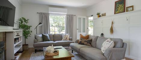 Una sala de estar con sofá, mesa de centro, chimenea y televisor.