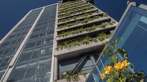 A modern building with a glass facade, vertical gardens, and a security camera. - GO Quito Hotel (Quito)