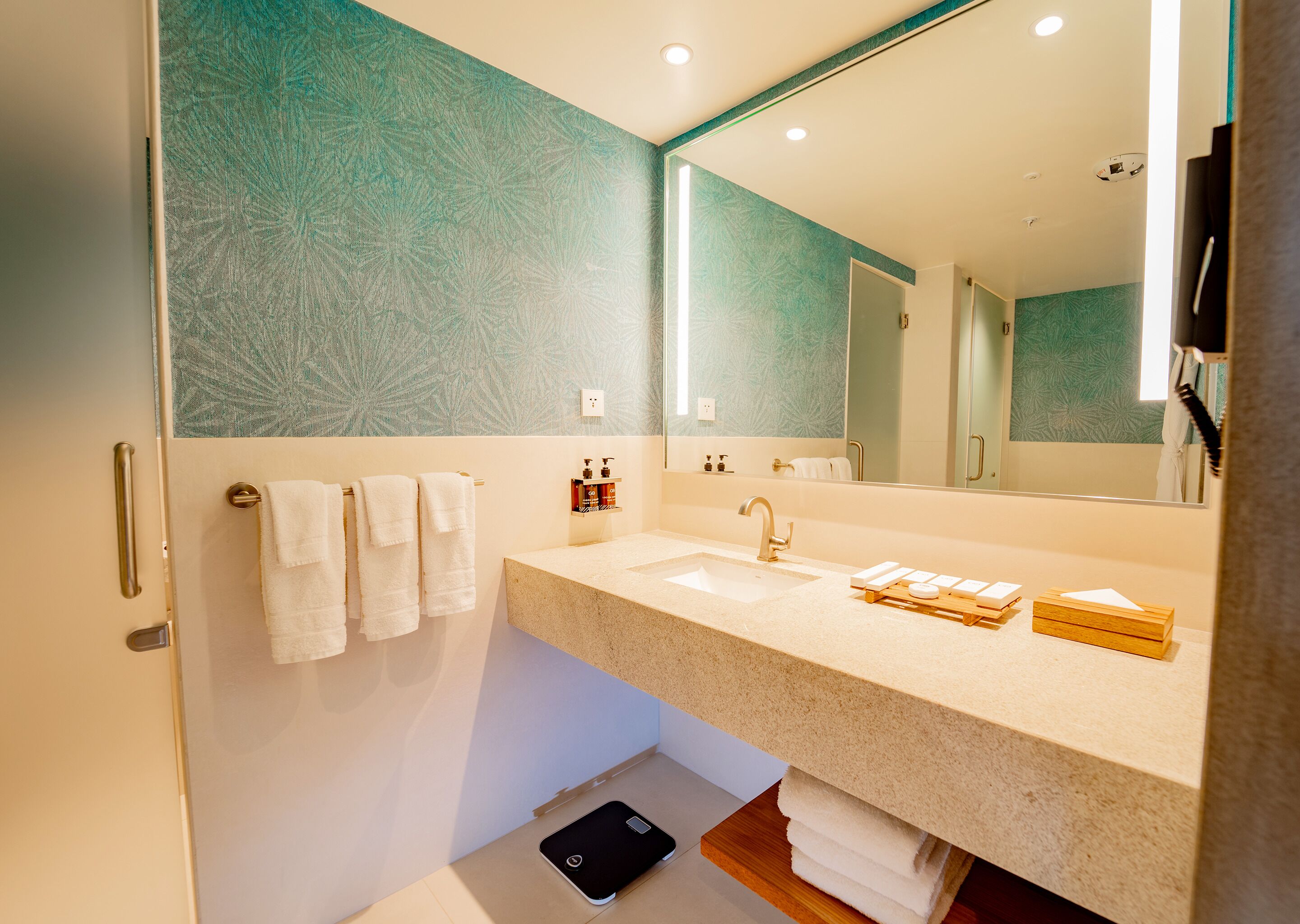 A modern bathroom with a large mirror, a sink, and a vanity.