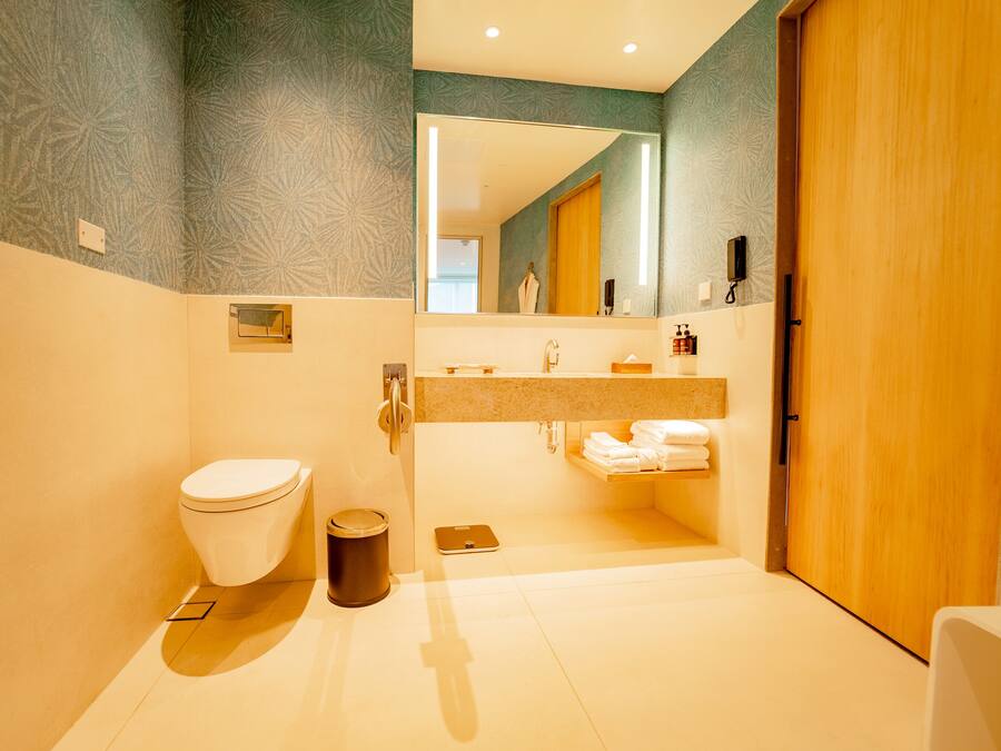 Un baño moderno con inodoro, lavamanos y espejo.
