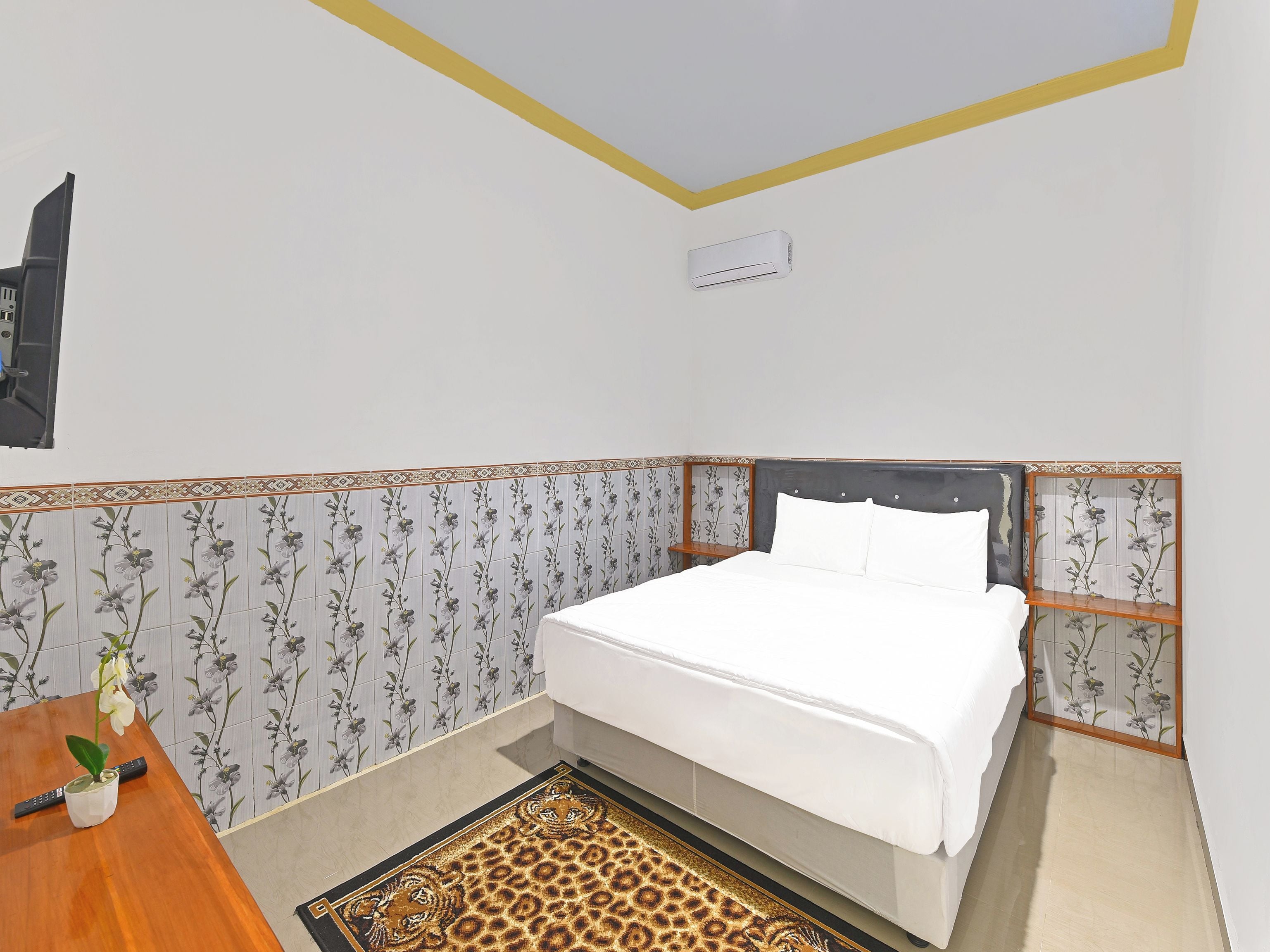 Een slaapkamer met een bed, een bureau en een stoel.