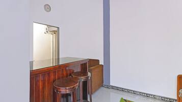 Un baño con espejo, tocador de madera y dos taburetes.