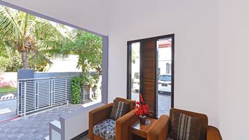 Una sala de estar moderna con dos sofás, una mesa de centro y vistas a la calle y zonas verdes.