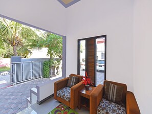 Een moderne woonkamer met twee banken, een salontafel en uitzicht op een straat en groen.