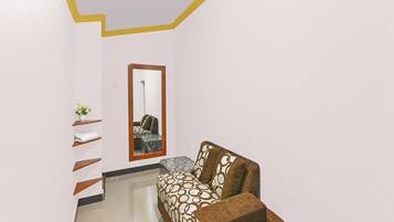 Una habitación con un sofá, un espejo y una planta en maceta.