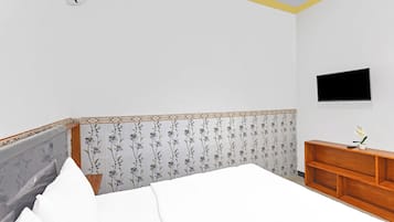 Un dormitorio con una cama, un aparador de madera, un televisor de pantalla plana y un aire acondicionado de pared.