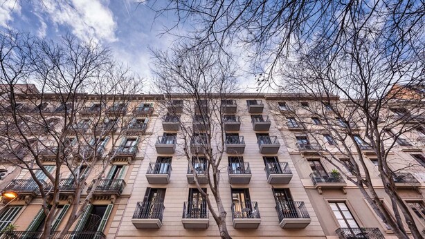 A multi-story building with balconies, a flat facade, and a clear sky. - Sweett | Bailen 404 - Two Bedroom Apartment, Sleeps 4 (Barcelona)