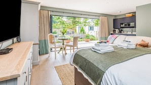 Una camera da letto moderna con un letto grande, una scrivania, una sedia e vista sul giardino.