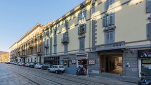 Una fila di edifici con negozi al piano terra, tra cui una panetteria e una pizzeria.