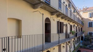 Un edificio a più piani con balconi, finestre ad arco e una facciata beige.