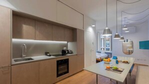 Una cucina moderna con forno integrato, lavello e zona pranzo con tavolo apparecchiato per la colazione.