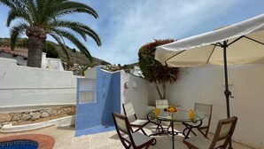 A patio with a round table, chairs, a small pool, and a palm tree. - Gorgeous villa with swimming pool on the Costa Blanca, 800m away from the beach. (Moraira)