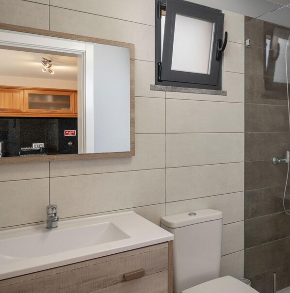 A bathroom with a sink, mirror, toilet, and shower. - Quality tranquil villa with sea-view | OceanScape (Poiso)