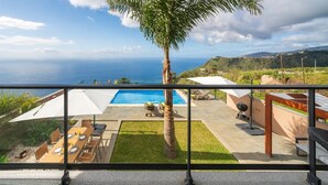 A balcony with a pool, outdoor furniture, and a view of the ocean. - Quality tranquil villa with sea-view | OceanScape (Poiso)