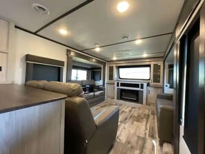Ein modernes Wohnmobil-Interieur mit einer Sitzecke, einer Küche und einem großen Fenster.