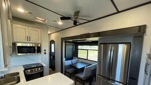 Cocina compacta para autocaravana con estufa, microondas y refrigerador.