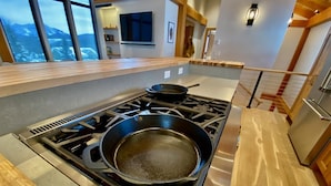A modern kitchen with a gas stove, a frying pan, and a wooden countertop. - Meridian Lake- Mountain Modern (Crested Butte)