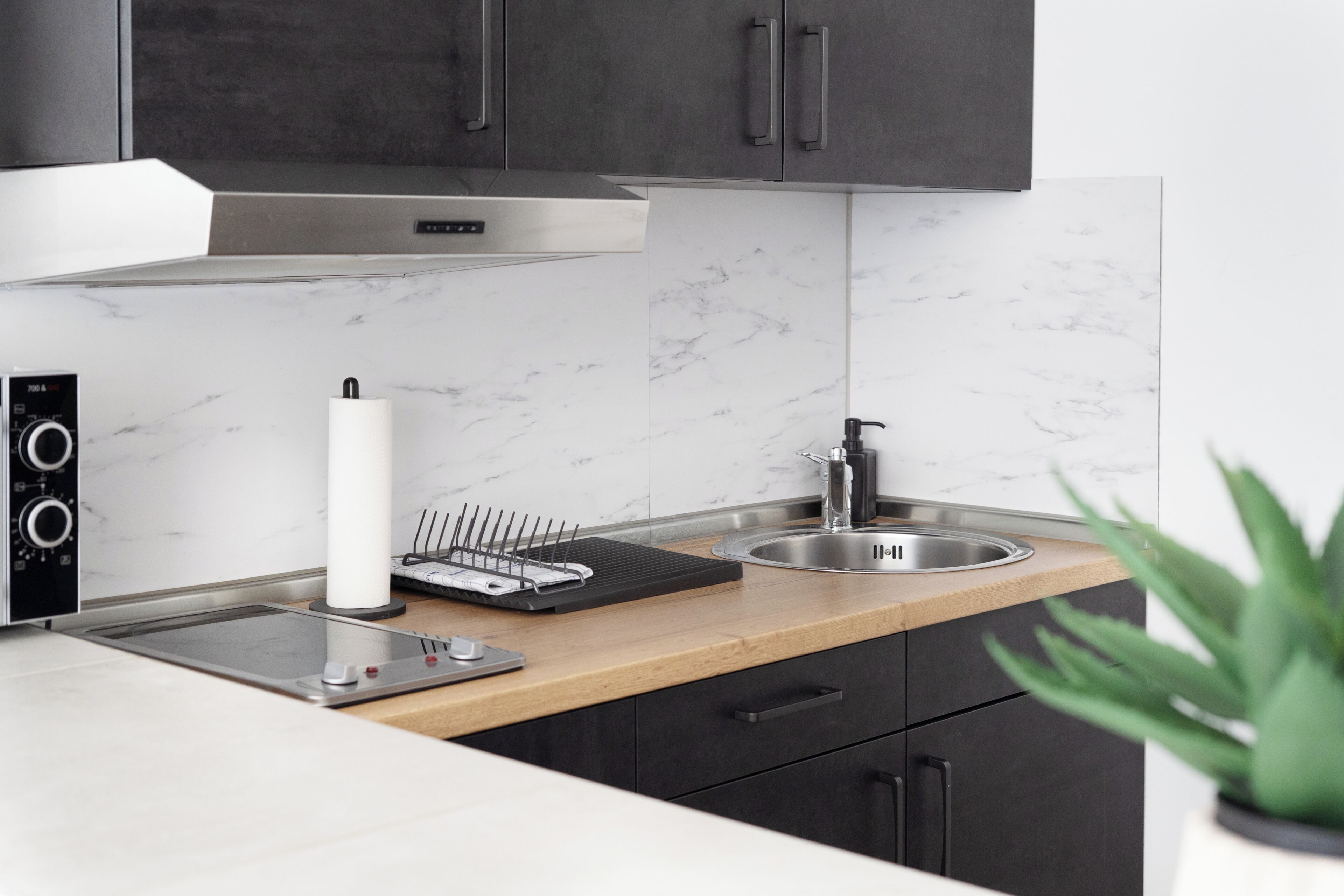 Eine moderne Küche mit Backofen, Spüle und einer schwarzen Arbeitsplatte.