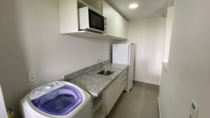 A compact kitchen with a built-in microwave, a sink, and a refrigerator.