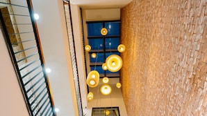 A modern interior with a staircase, a brick wall, and multiple hanging lights. - LaSanta Villa (Da Nang)