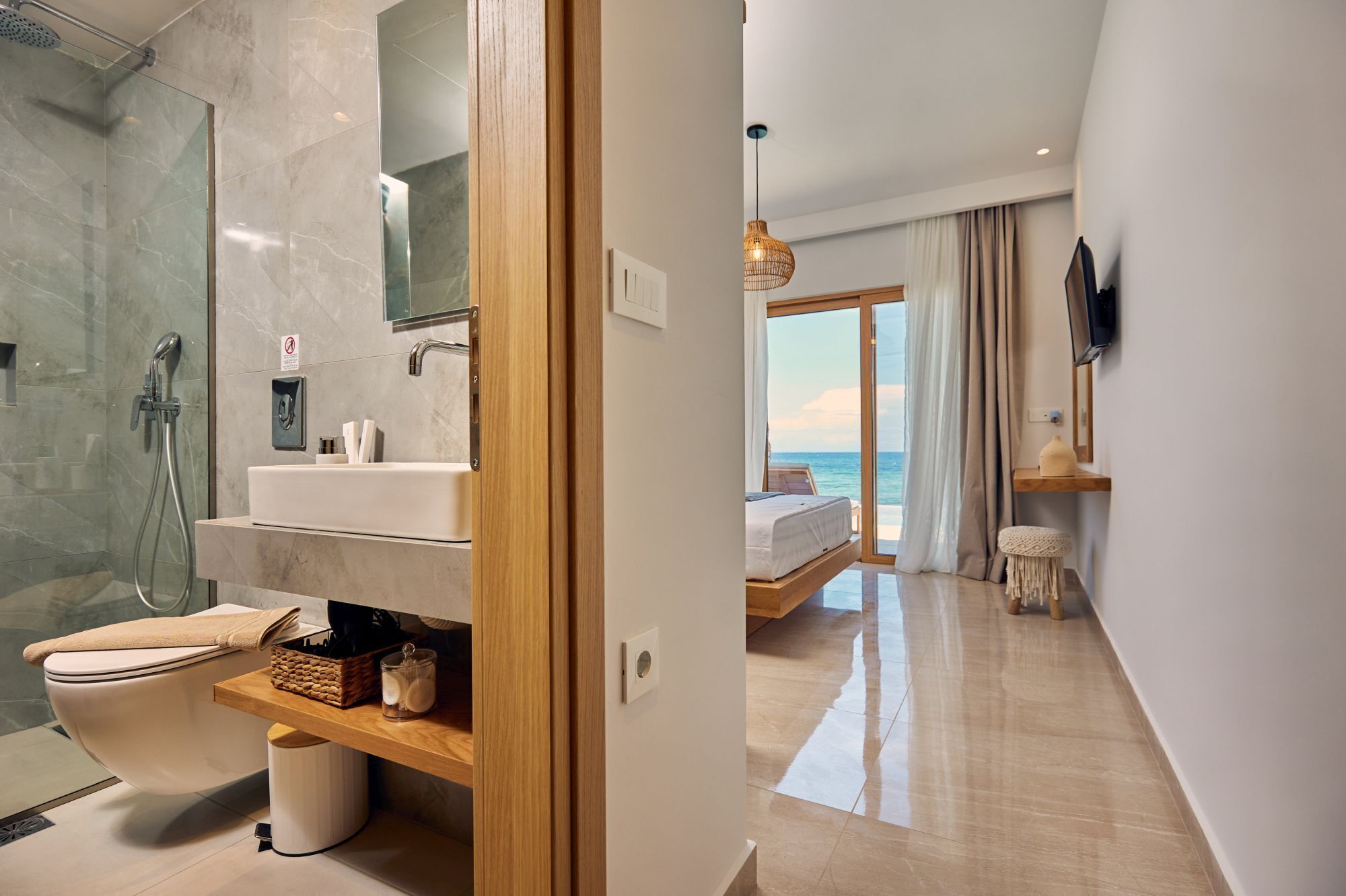 A modern bathroom with a glass shower enclosure, a white sink, and a toilet.