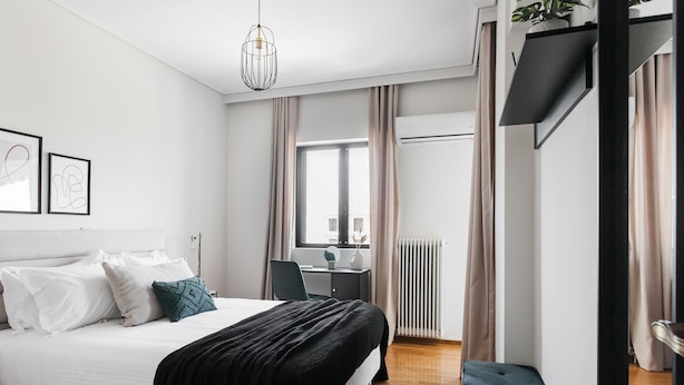 Une chambre moderne avec un lit, une table de chevet et un bureau avec une chaise.