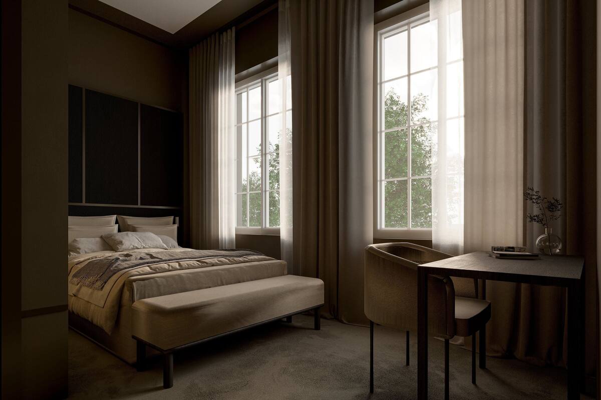 A bedroom with a bed, a desk, and a chair.