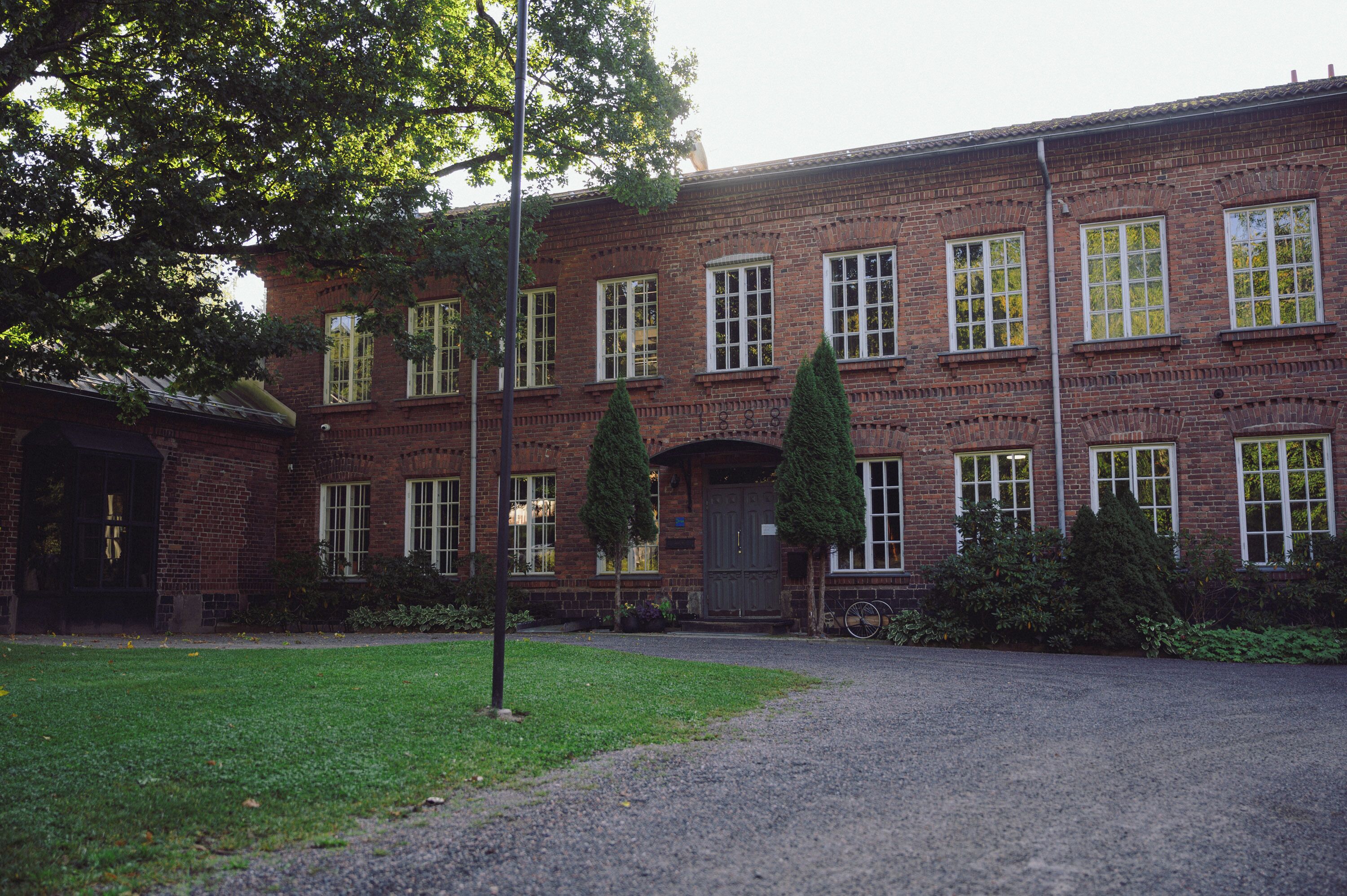 A red brick building with multiple windows and a central entrance.
