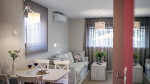 A modern living room with a dining area, a sofa set, and a coffee table. - apartment C - Red Apartment (Vir)