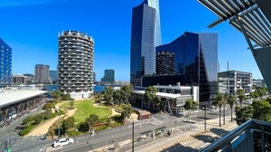 Un paisaje urbano moderno con arquitectura distintiva, incluyendo un edificio cilíndrico con un diseño único y un rascacielos alto.