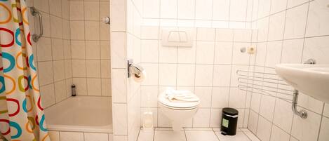 A small bathroom with a shower, toilet, and sink.