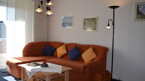 Un salon avec un canapé, une table basse et un lampadaire.