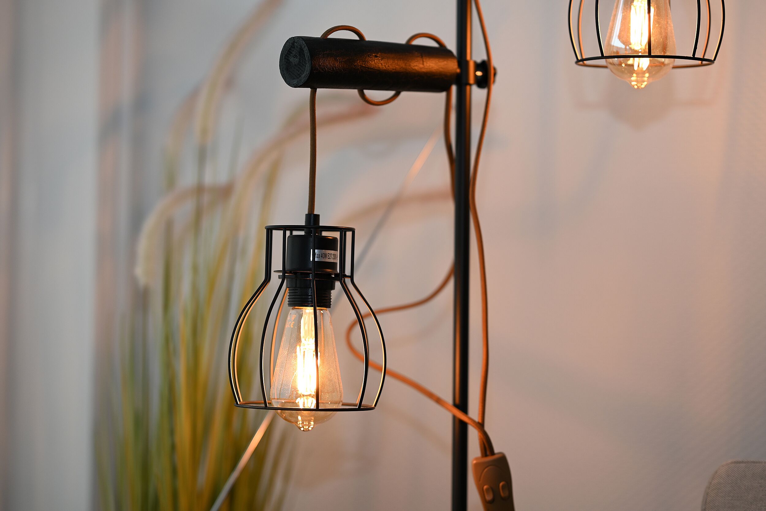 A close-up of a modern light fixture with a clear glass bulb and a metal frame.