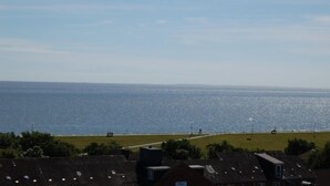 A coastal residential area with houses and a beach in the background. - Büsumer Kuschelnest mit Meerblick (Büsum)