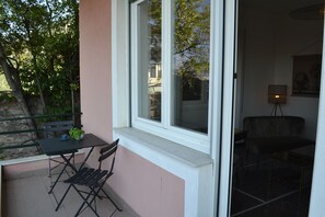 A room with a window, a table with chairs, and a bench outside. - Cozy 3-Bedroom House on the Riviera (Chiavari)