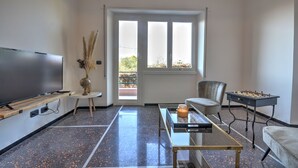A modern living room with a flat-screen TV, a coffee table, a sofa, and a foosball table. - Cosy Home Riviera 3BDR (Chiavari)
