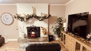 A living room with a fireplace, a television, and a Christmas tree. - Convenient Location-Private watch the sun come up over a beautiful pasture (Greer)