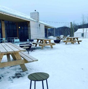 Guests can enjoy meals and relaxation in this outdoor seating area with picnic tables and chairs.