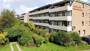 Un edificio de varios pisos con tejado plano, balcones y un cartel que indica que es una residencia estudiantil.