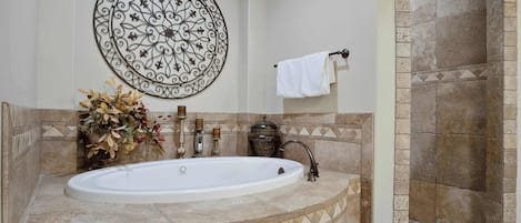Ein Badezimmer mit freistehender Badewanne, einem Wanddekor, einem Handtuchhalter und einer Duschkabine.