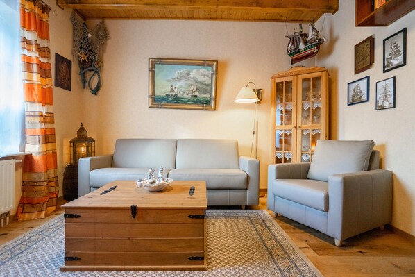 A cozy living room with a sofa, armchairs, a wooden coffee table, and a cabinet with glass doors. - Tolle 3-raum Ferienwohnung im Zentrum von Büsum. Perfekt für Büsum-liebhaber (Büsum)
