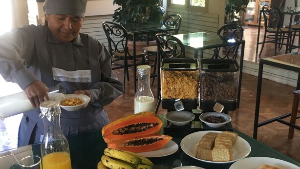 Un bufé de desayuno con diversas opciones de comida, como frutas, cereales y bebidas.