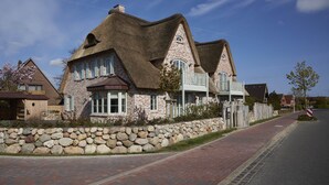 A stone house with a thatched roof and a stone wall. - Dreamlike vacation under thatch - Reethus "de Tweeling" Apartment ground floor (Büsum)