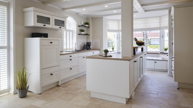 A modern kitchen with white cabinetry, a central island, and a large window providing natural light. - Dreamlike vacation under thatch - Reethus "de Tweeling" Apartment ground floor (Büsum)